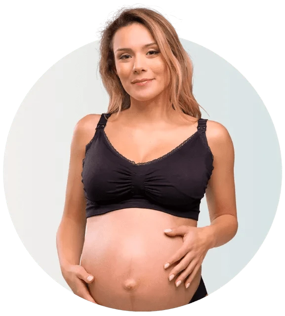 Pregnant woman wearing a black maternity bra against a light background