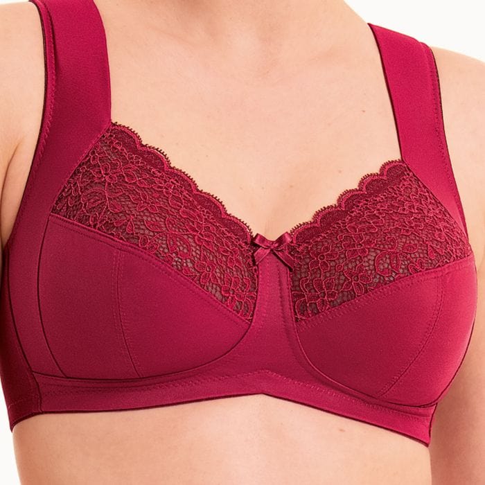 Woman wearing an anita Havanna Red bra with lace detailing on a plain background