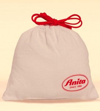 Beige drawstring bag with medical fleece inside tied with red bow and 'Anita' logo on a beige background