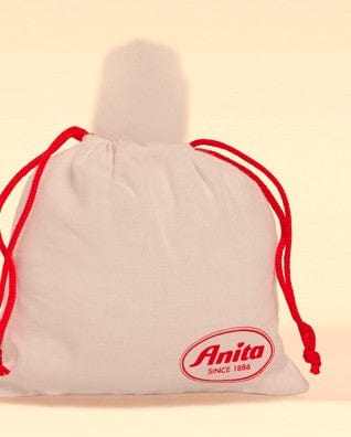 White drawstring bag filled with medical fleece with red strings and 'Anita' logo on a beige background