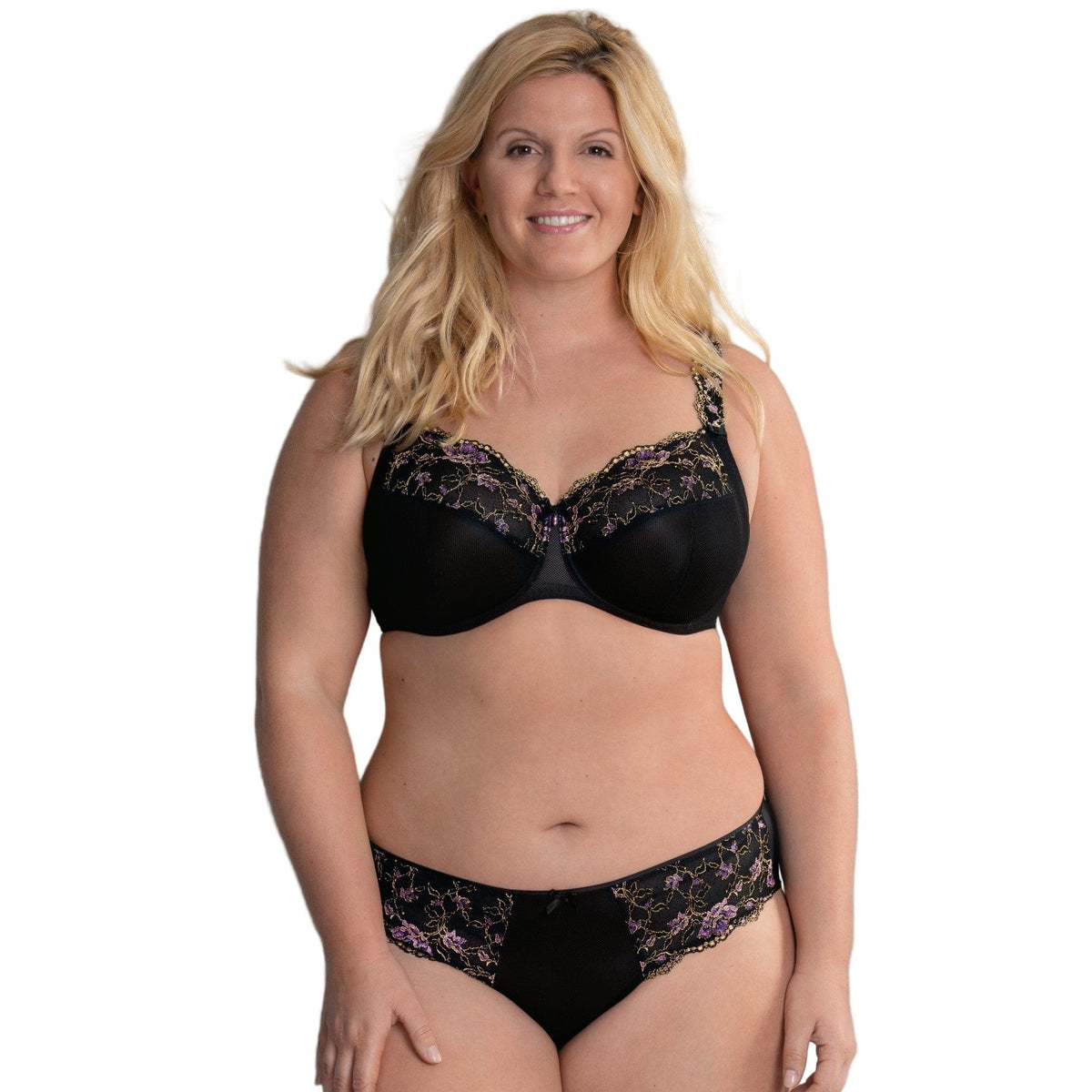 Woman wearing an Anita Rosa Faia Full cup black lace bra with embroidery and lace panties against a white background.