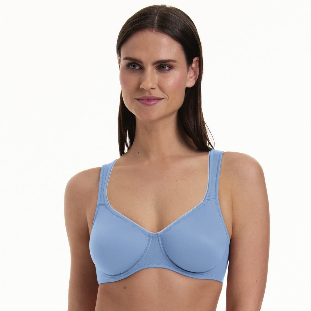 Woman wearing a seamless underwired light blue bra on a white background