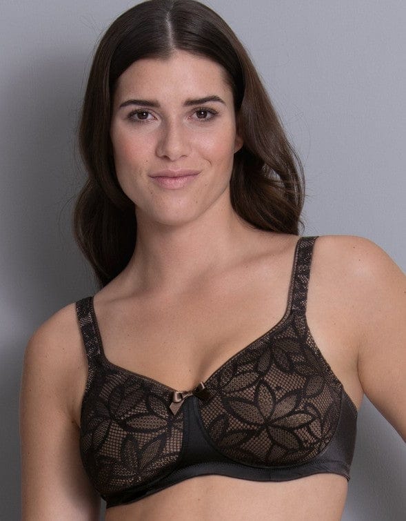 Woman wearing a black lace mastectomy bra with pockets against a grey background