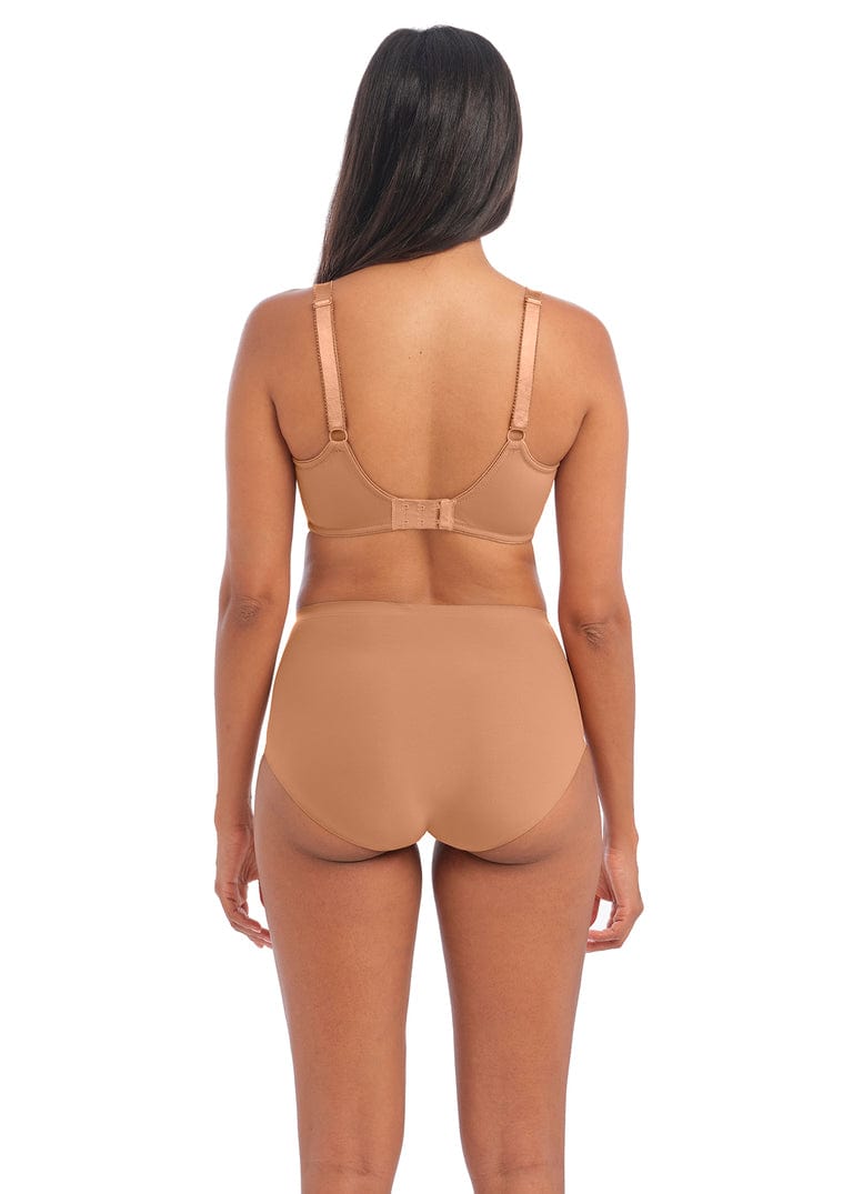 Person wearing a beige bodysuit on a white background